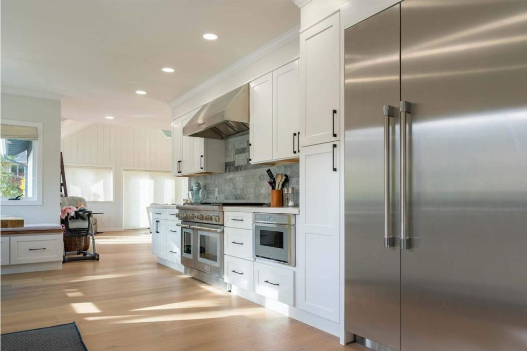 Contemporary kitchen remodel featuring clean white slab cabinets with minimalist styling and modern finishes
