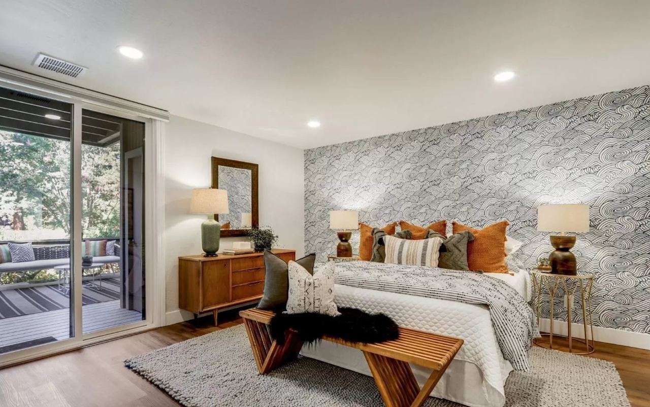 Elegant room addition contractors Honolulu master bedroom featuring stunning stone accent wall with modern furnishings