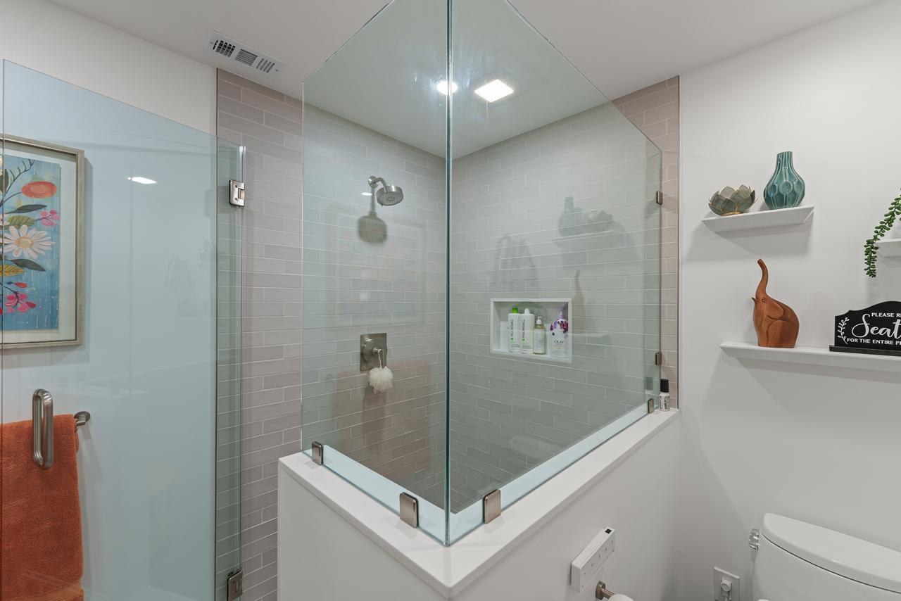Bathroom after: frameless glass enclosed walk in shower with gray subway tile and frameless tempered glass, by ASL Remodeling.