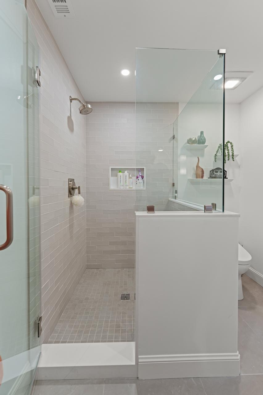Bathroom after: frameless glass walk in shower enclosure with subway tile and mosaic floor tile, by ASL Remodeling.