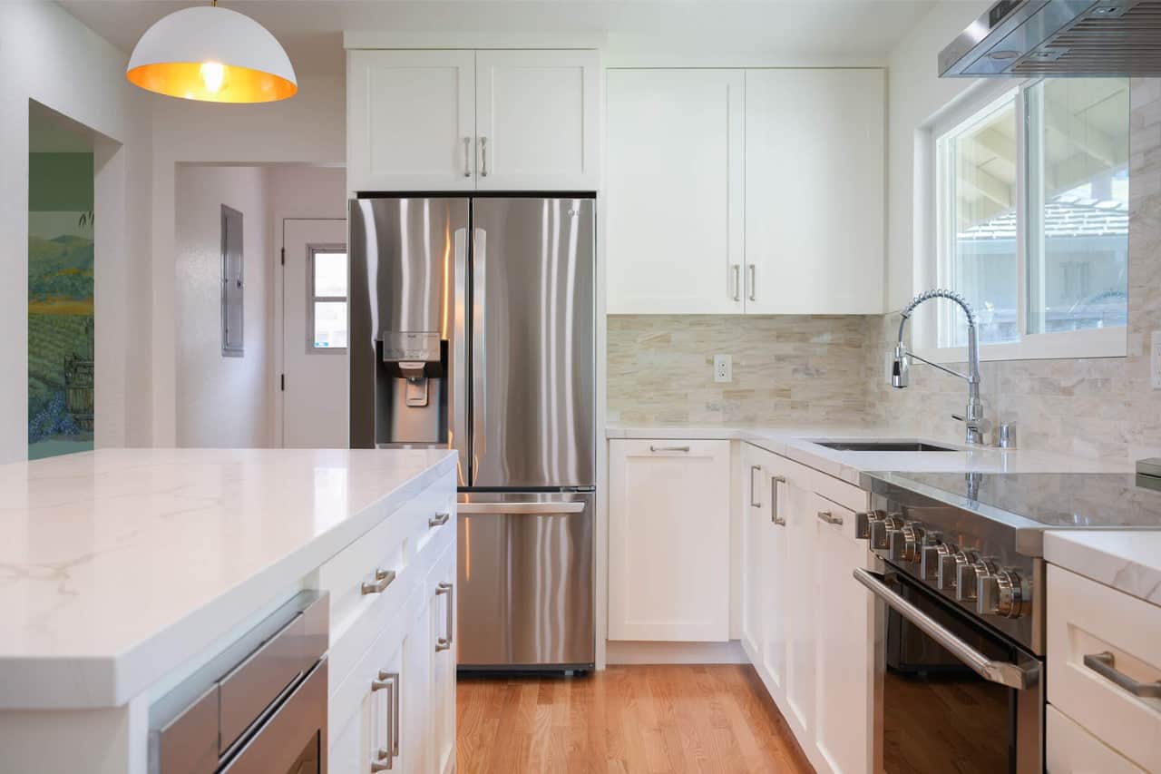 Kailua kitchen remodel with large format porcelain tile and two tone shaker cabinetry in Coconut Grove home