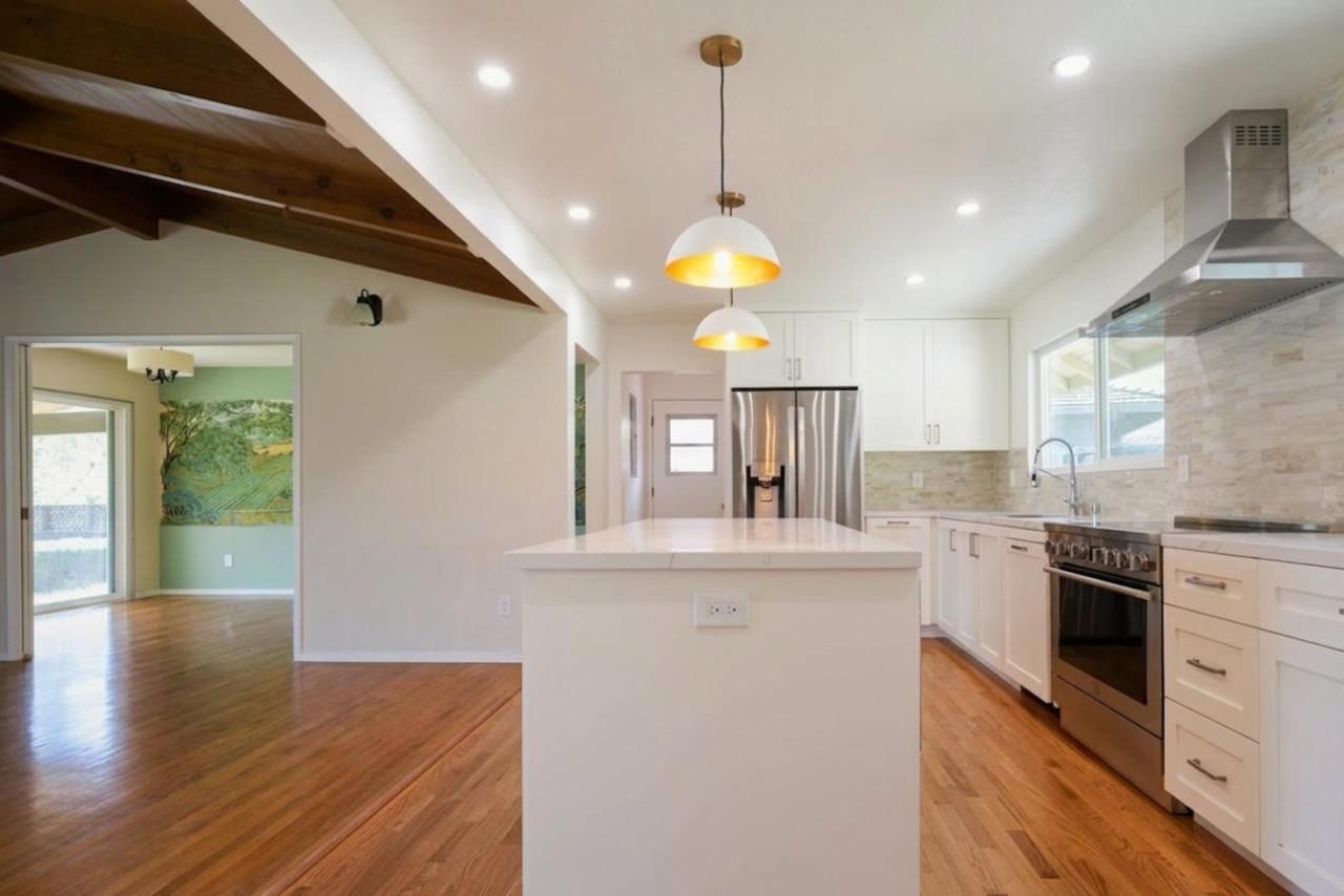 Kitchen after: white shaker cabinets with quartz island with quartz countertop and white shaker cabinetry, by ASL Remodeling.