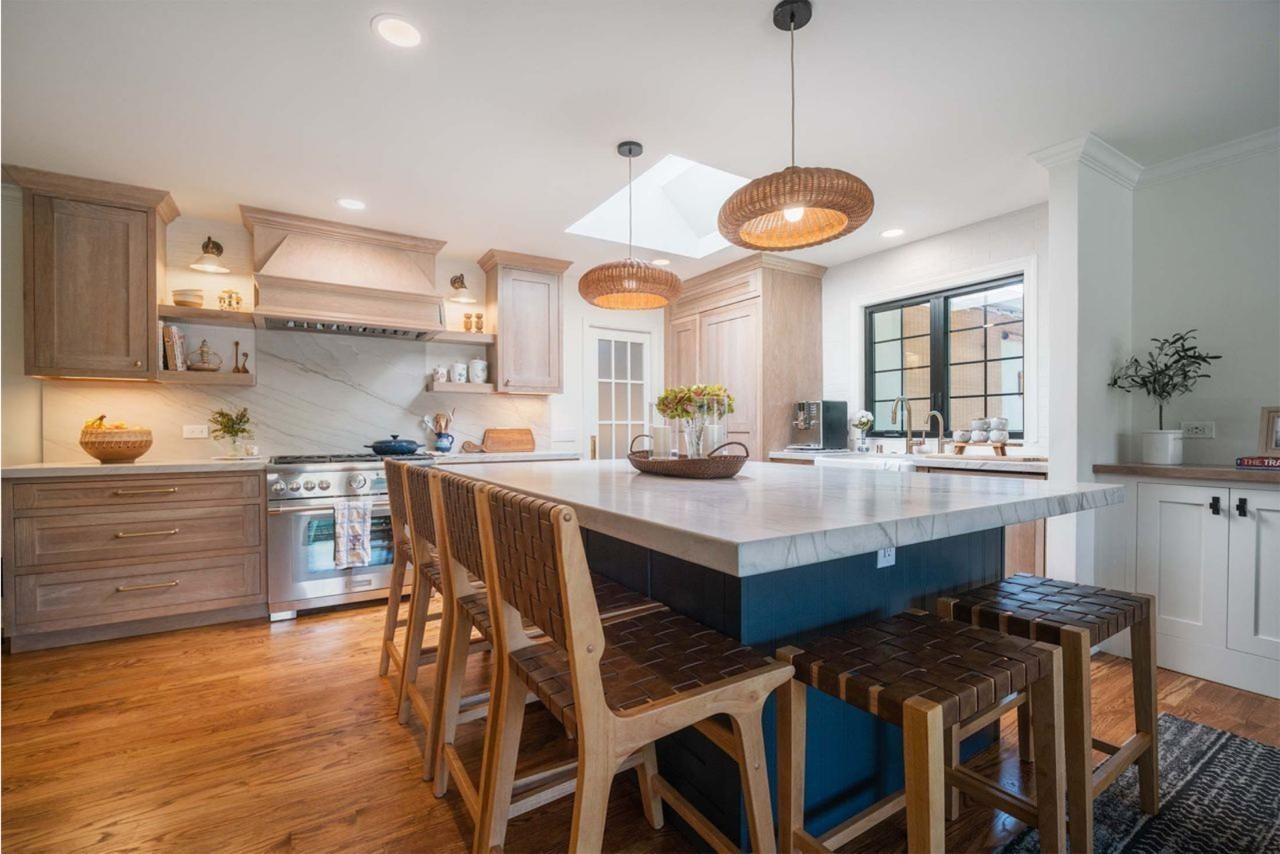 Home remodel kitchen featuring custom maple cabinetry, natural quartzite countertops, floating shelves, and open concept flow to dining area