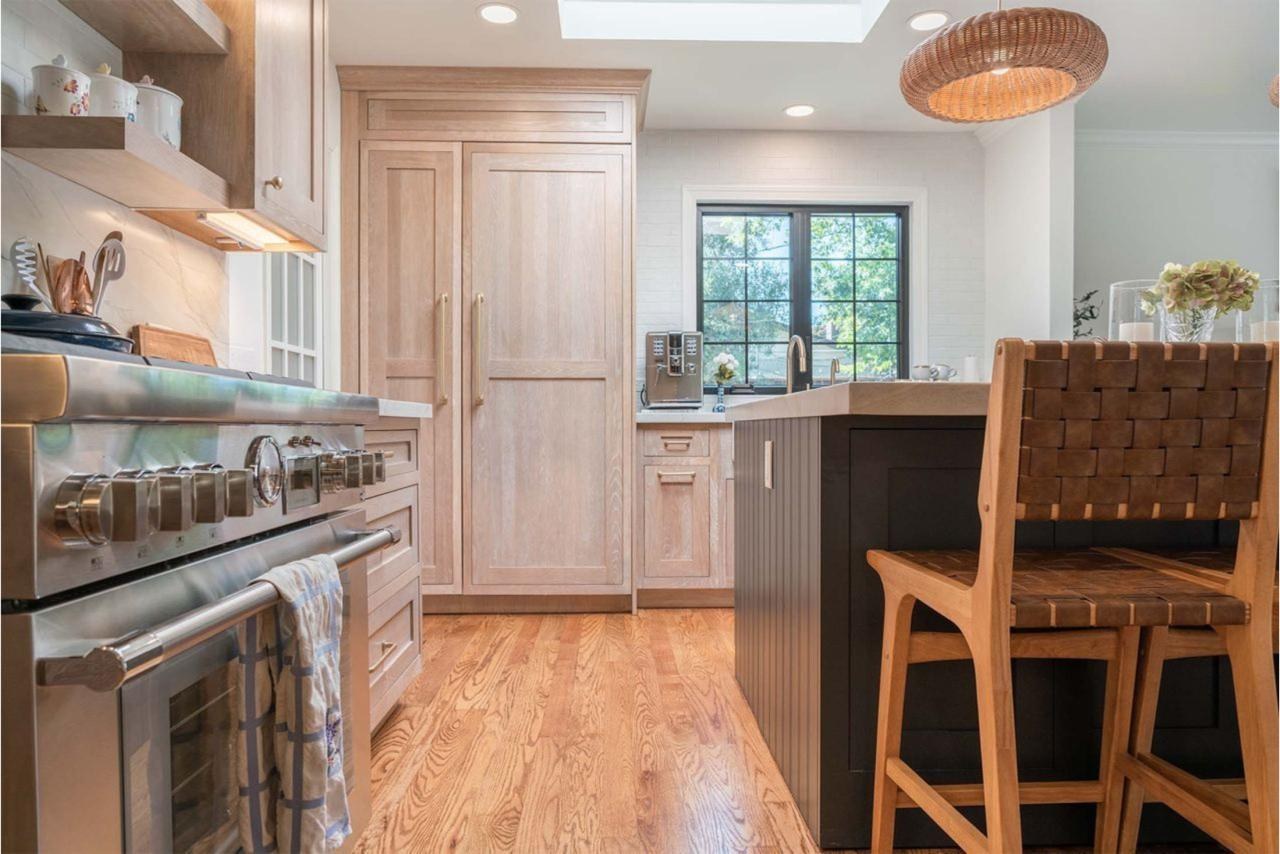 Open concept kitchen remodel with floating shelves, seamless backsplash, custom maple cabinetry, and contemporary design with hardwood flooring