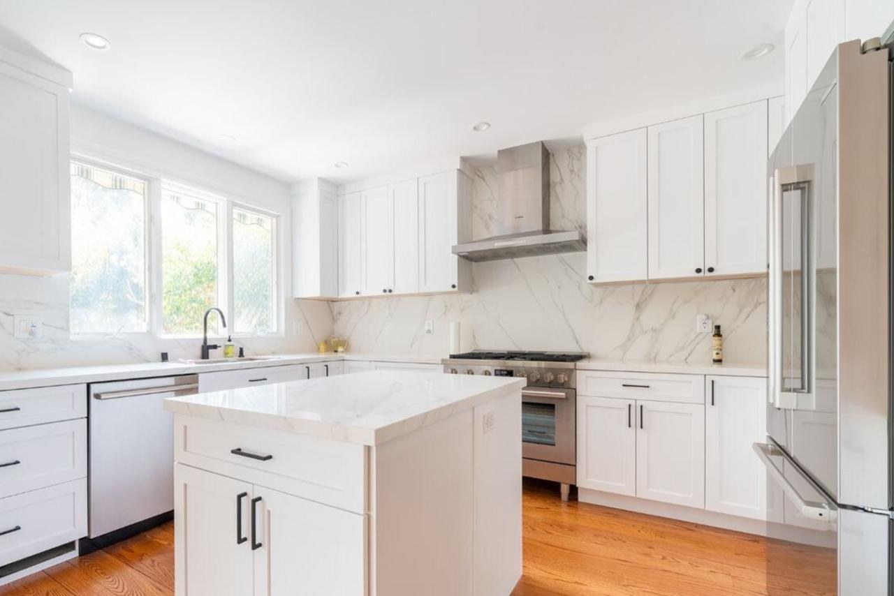 Kitchen: white shaker cabinets with marble slab backsplash with marble look quartz countertops and backsplash and white shaker cabinets, by ASL Remodeling.