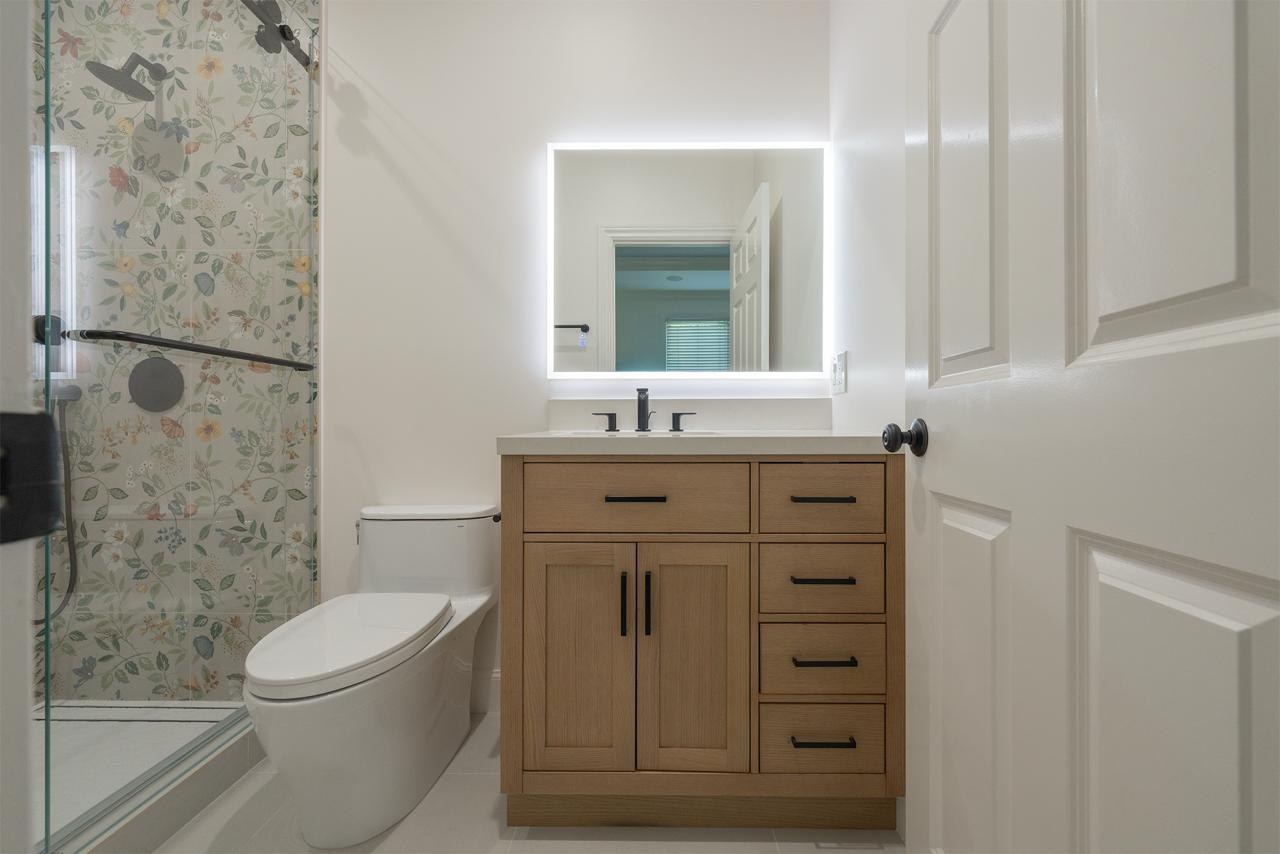 Bathroom remodel with wood vanity and mirror by ASL Remodeling