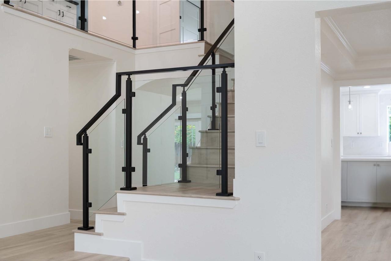 Home remodel with modern staircase featuring matte black railing, tempered glass panels, and white oak hardwood treads