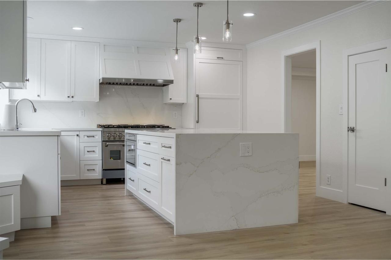 Kitchen with custom maple cabinetry, panel-ready Thermador appliances, quartzite island, and white oak hardwood flooring