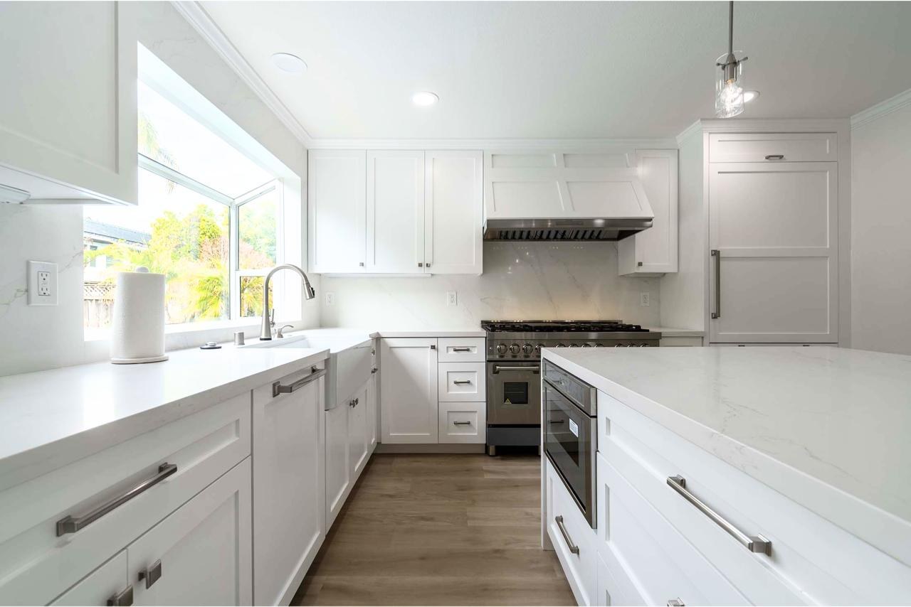 Kitchen with panel-ready Thermador appliances, full slab quartzite backsplash, and white oak hardwood flooring