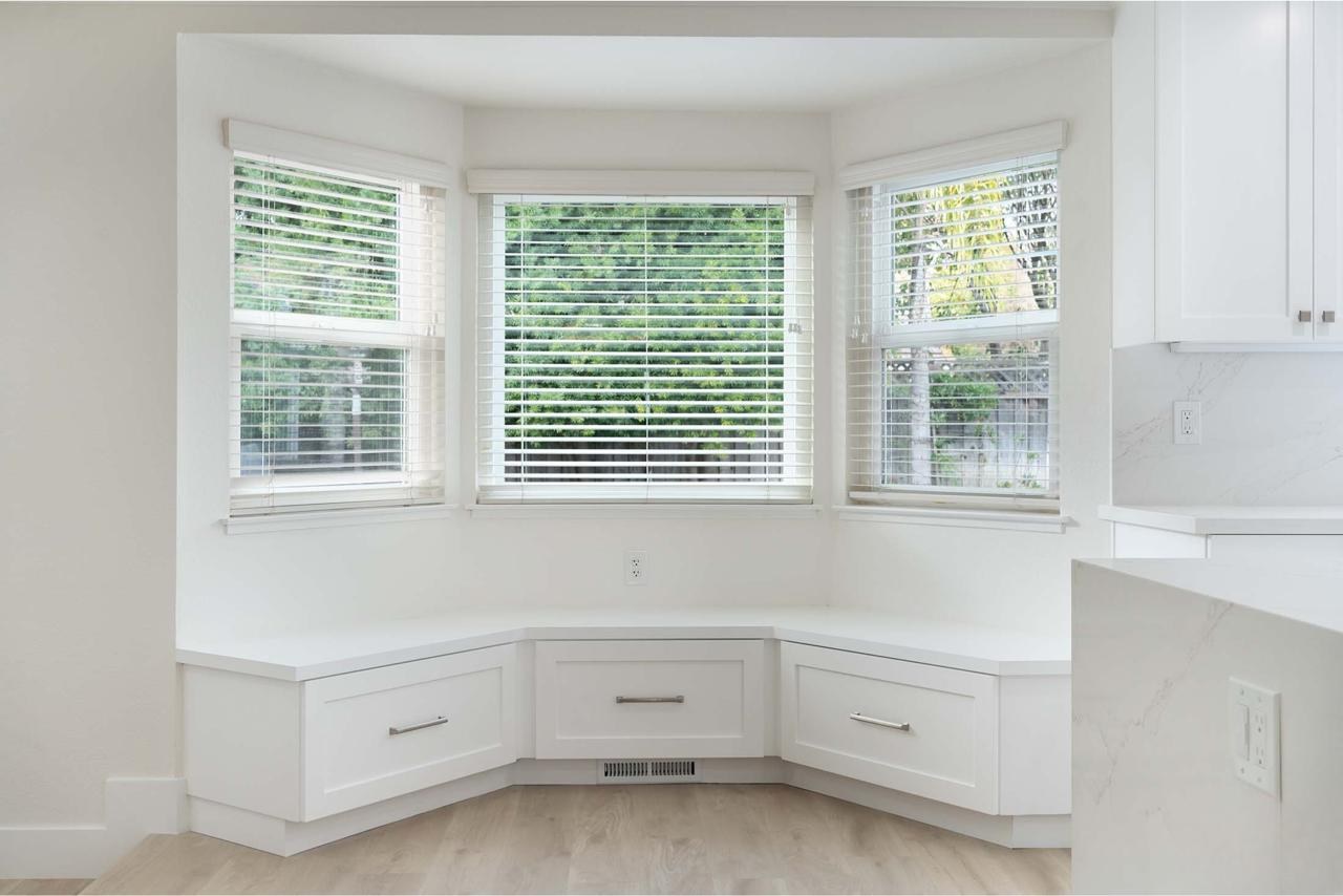 Kitchen with built-in breakfast nook, under-seat deep drawers, bay window seating, and custom cabinetry storage