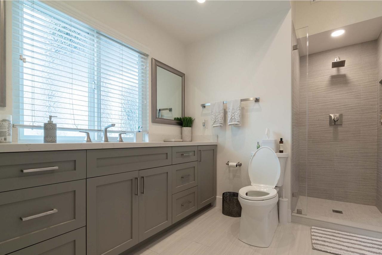 Bathroom featuring floating vanity with natural light, frameless glass shower, and carefully curated tilework