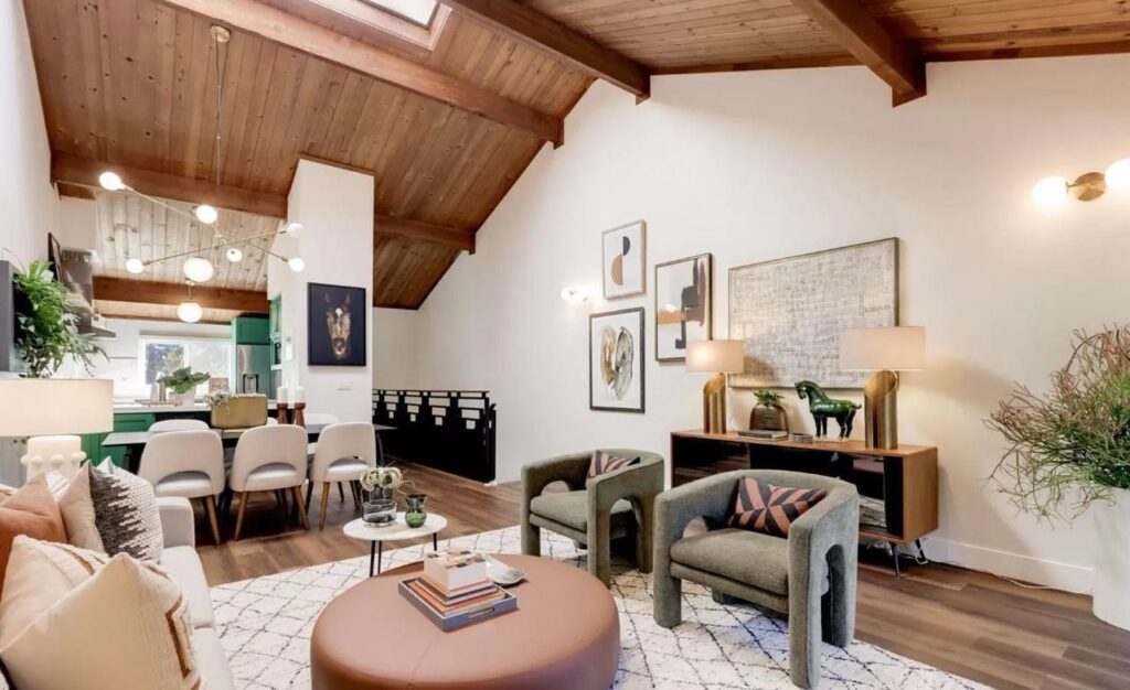Home remodel showing open concept living and dining area with wood ceiling, exposed beams, and wide-plank flooring