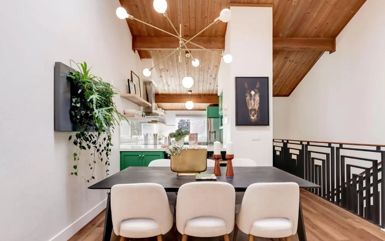 Home with dining area, wood ceiling with exposed beams, modern metal stair railing, and open shelving