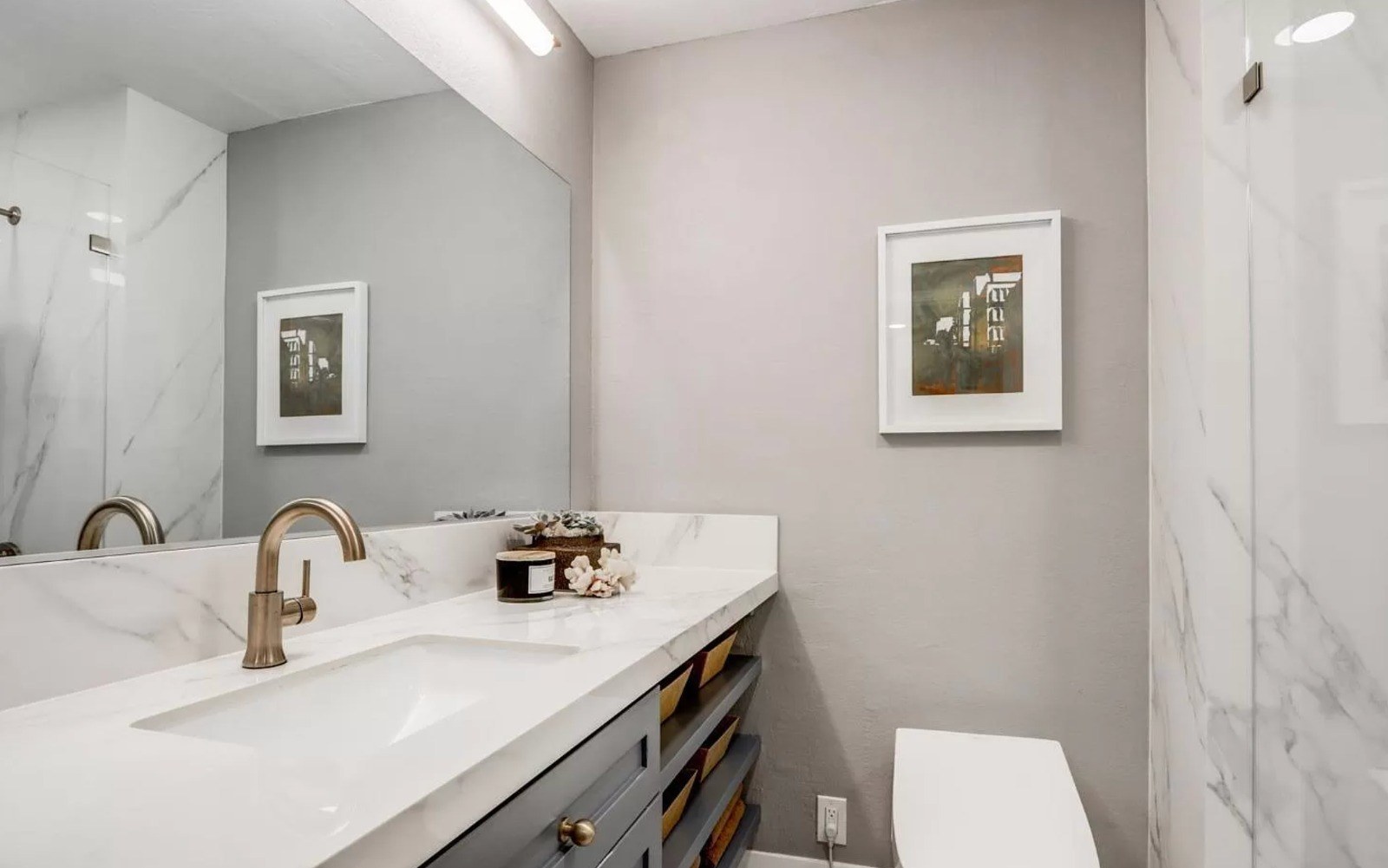 Bathroom featuring custom cabinetry, porcelain countertops, modern fixtures, and clean contemporary finishes