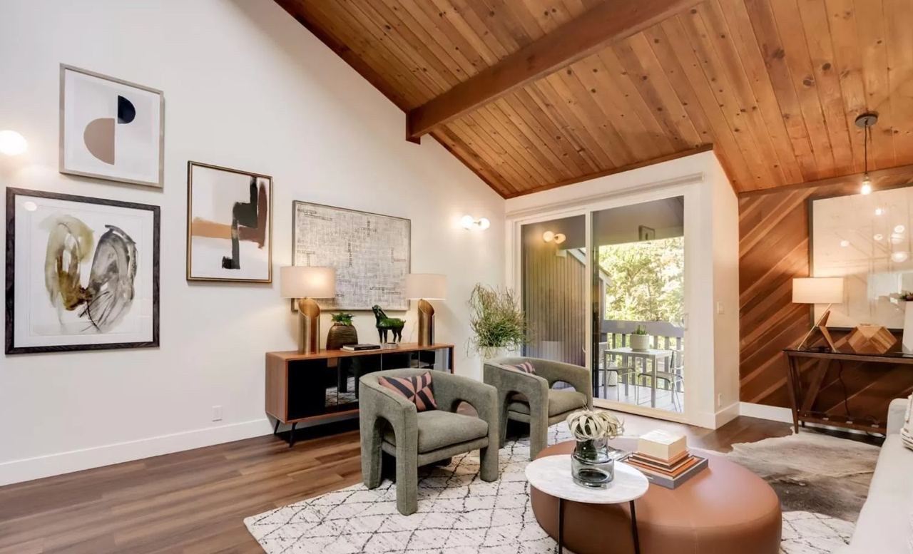 Living room with wood ceiling, exposed beams, diagonal wood accent wall, and wide-plank flooring throughout