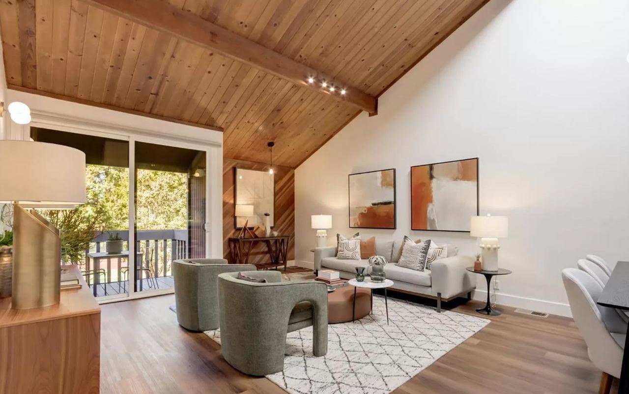 Living room featuring wood ceiling, diagonal wood accent wall, deck access, and wide-plank floating vinyl flooring