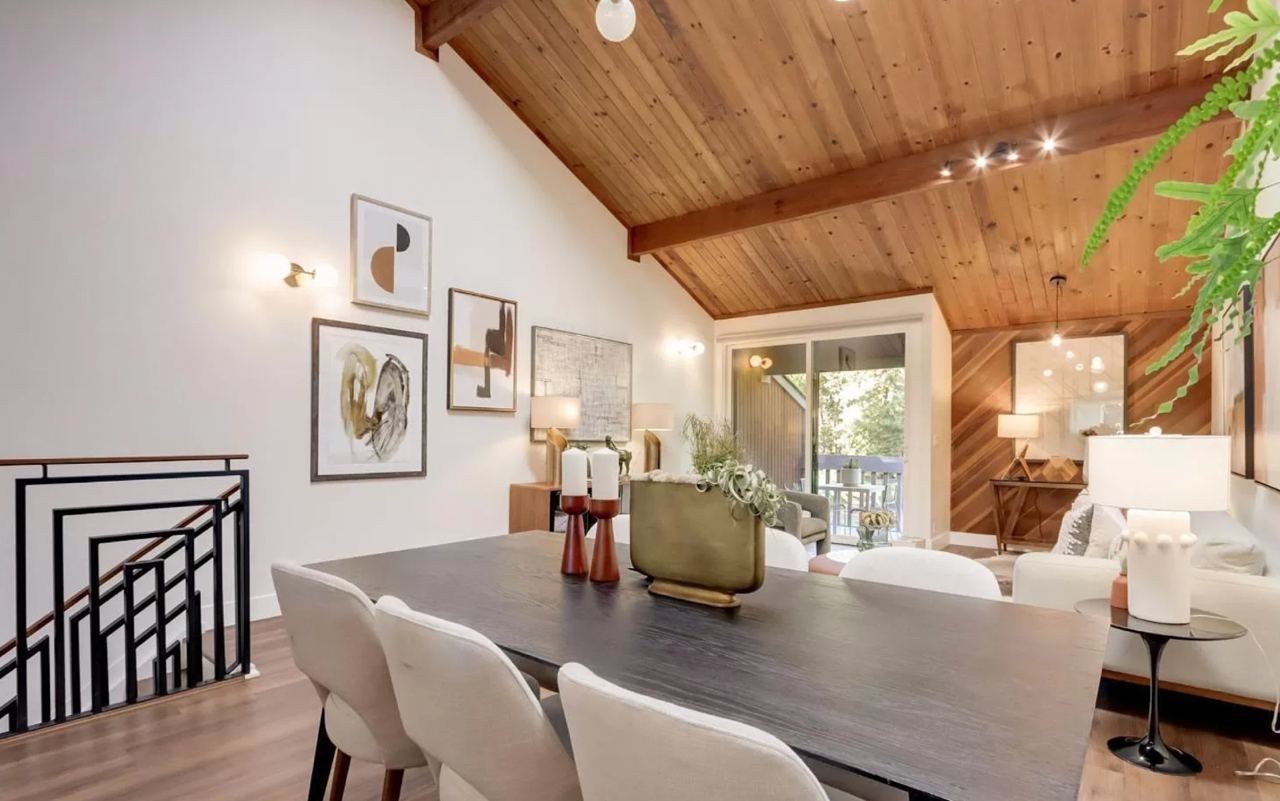 Dining area with wood ceiling, exposed beams, modern metal stair railing, and diagonal wood accent wall
