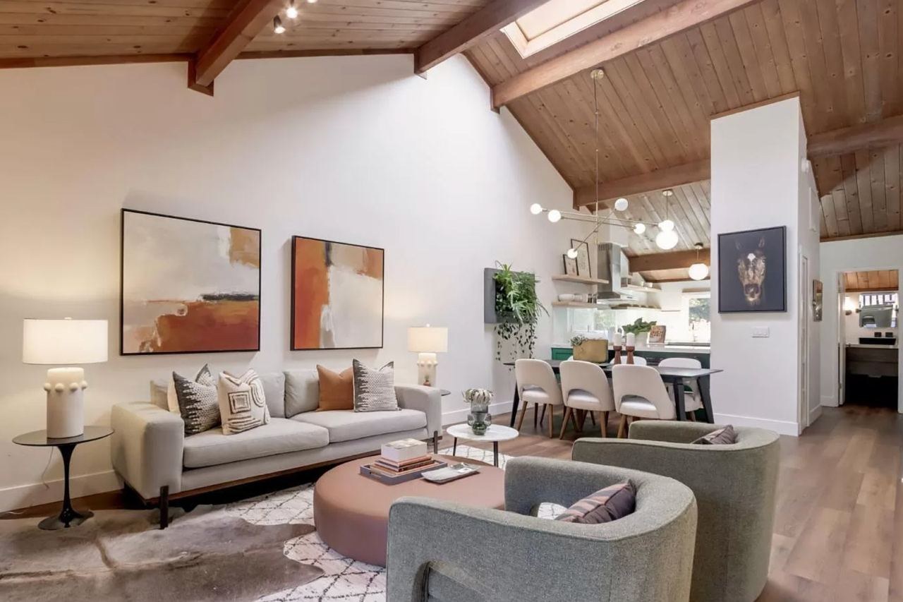 Home remodel with open concept living area, wood ceiling with skylight, exposed beams, and wide-plank floating vinyl flooring