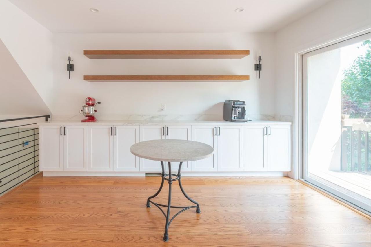 Kitchen: floating wood shelves over white shaker cabinets with white shaker cabinetry and marble countertop, by ASL Remodeling.
