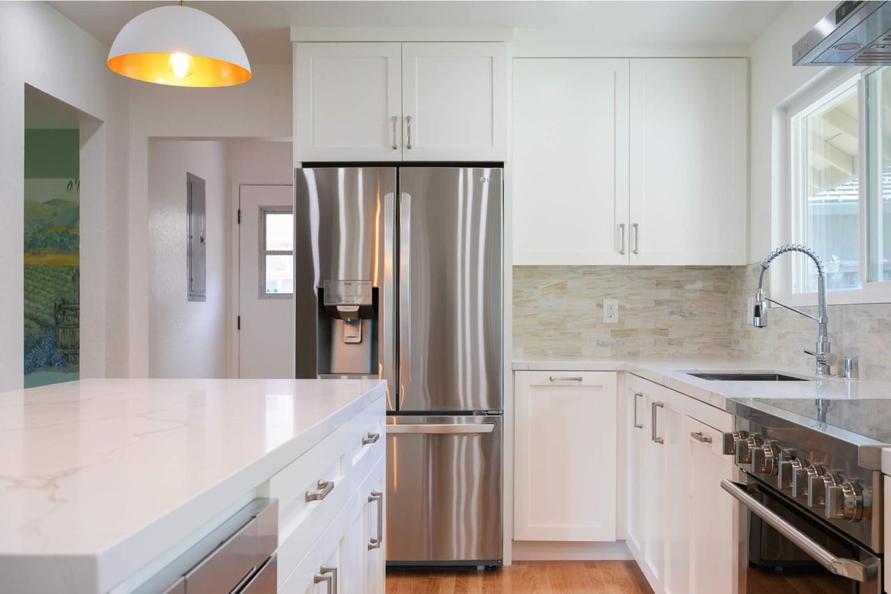 White shaker cabinets with quartz waterfall island after, ASL Remodeling