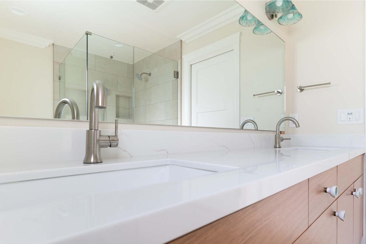 Primary bathroom after: double sink quartz vanity with wood cabinetry with white quartz countertop and light oak wood cabinetry, by ASL Remodeling.