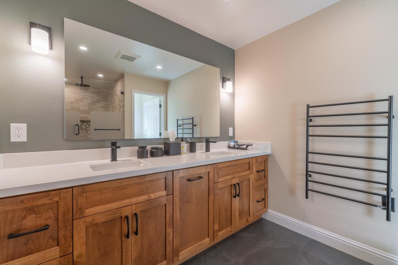 Primary bathroom: double sink wood vanity with quartz countertop with wood cabinetry and quartz countertop, by ASL Remodeling.
