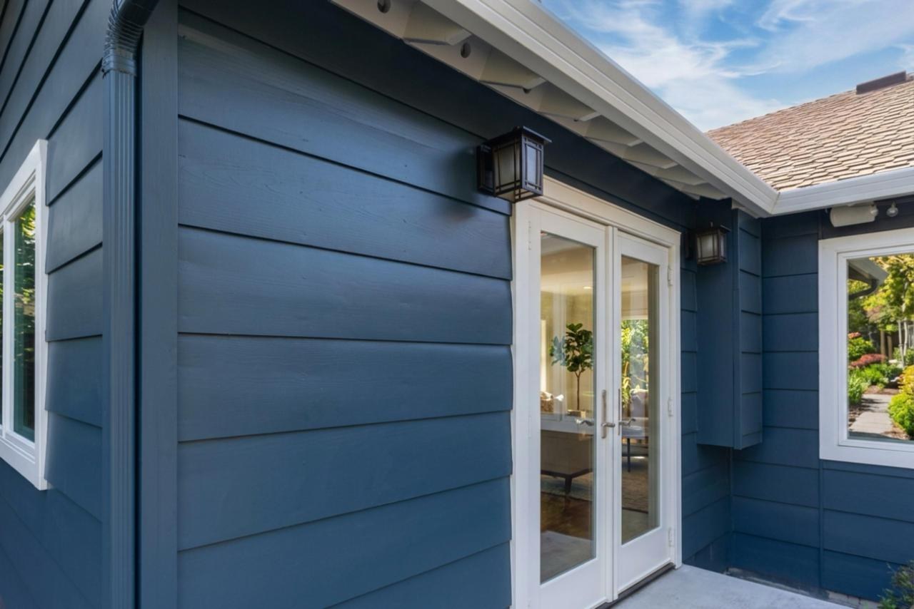 Exterior after: navy blue lap siding with white trim windows with fiber cement lap siding and asphalt shingle roofing, by ASL Remodeling.