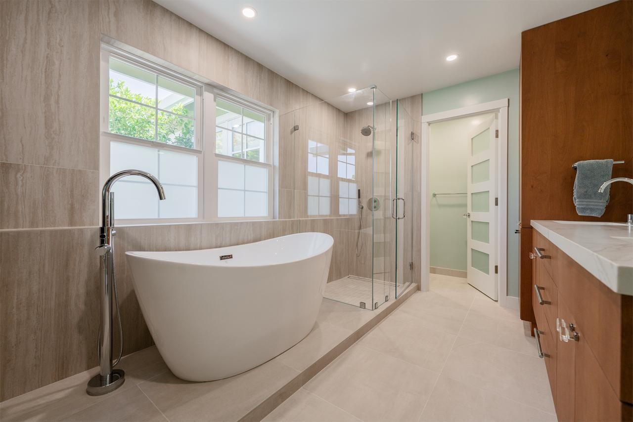 Master bathroom with a freestanding tub and a custom walnut vanity