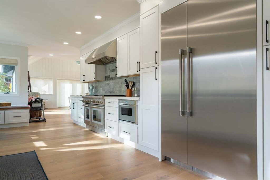 Kitchen remodel featuring custom cabinetry, open layout, engineered white oak hardwood flooring, and modern appliances
