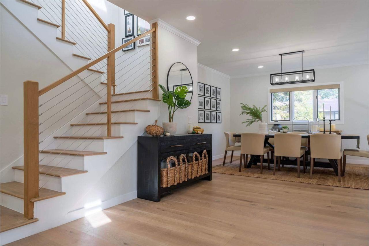 Home remodel showcasing completed modern staircase with white oak treads and cable railing creating open flow by ASL Remodeling