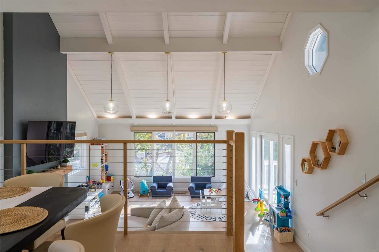 Home remodel showing open living area from loft with cable railing, vaulted ceiling, and engineered white oak flooring