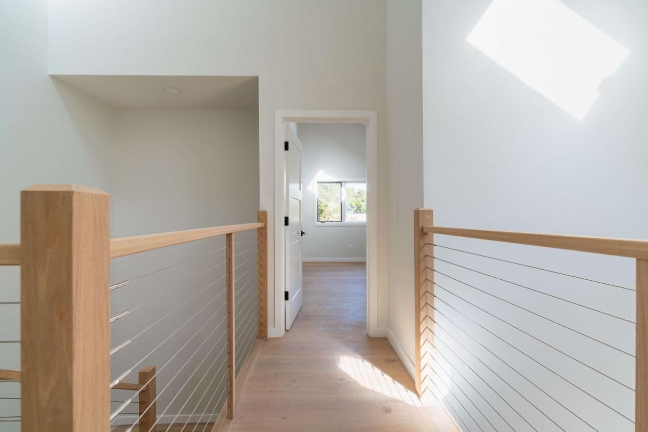 Home with upstairs hallway, modern cable railing, engineered white oak hardwood flooring, and natural light