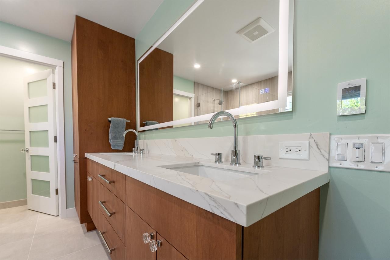 Walnut vanity with soft-close drawers and a Calacatta quartz countertop